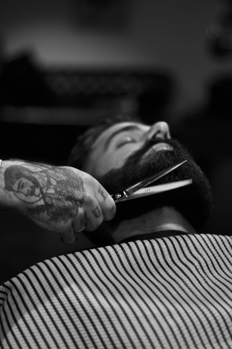 Alumno de barbería practicando perfilado de barba con tijera